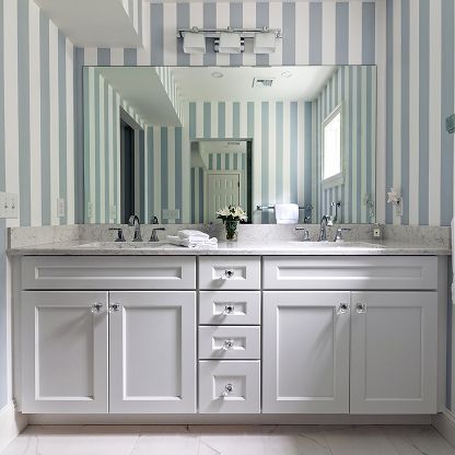 Bright bathroom vanity with double sinks, large mirror, and blue-and-white striped walls