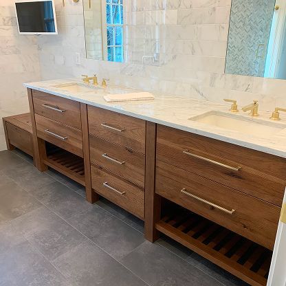 Modern bathroom vanity with double sinks, wood drawers, marble countertop, and wall mirror