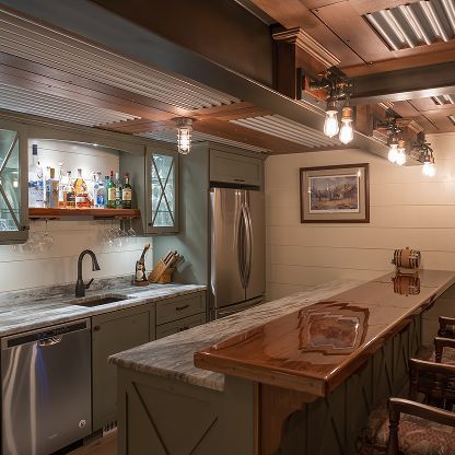 Warm rustic kitchen with stainless steel appliances, marble island, and hanging lights