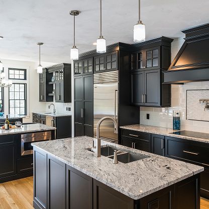 Modern kitchen with dark cabinets, granite island, stainless appliances, and pendant lights