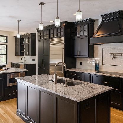 Modern kitchen with dark cabinets, granite island, pendant lights, and stainless steel appliances