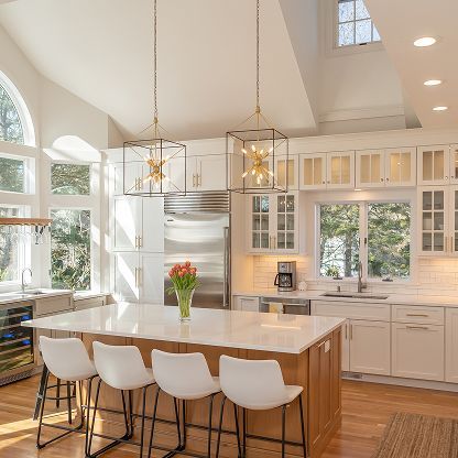 Bright modern kitchen with white cabinets, island, pendant lights, and hardwood floors