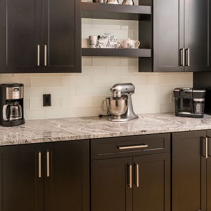 Modern kitchen with dark cabinets, granite countertop, coffee makers, and a stand mixer on the counter