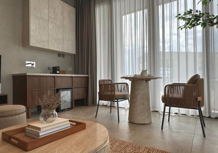 A living room with a table and chairs in front of a large window.