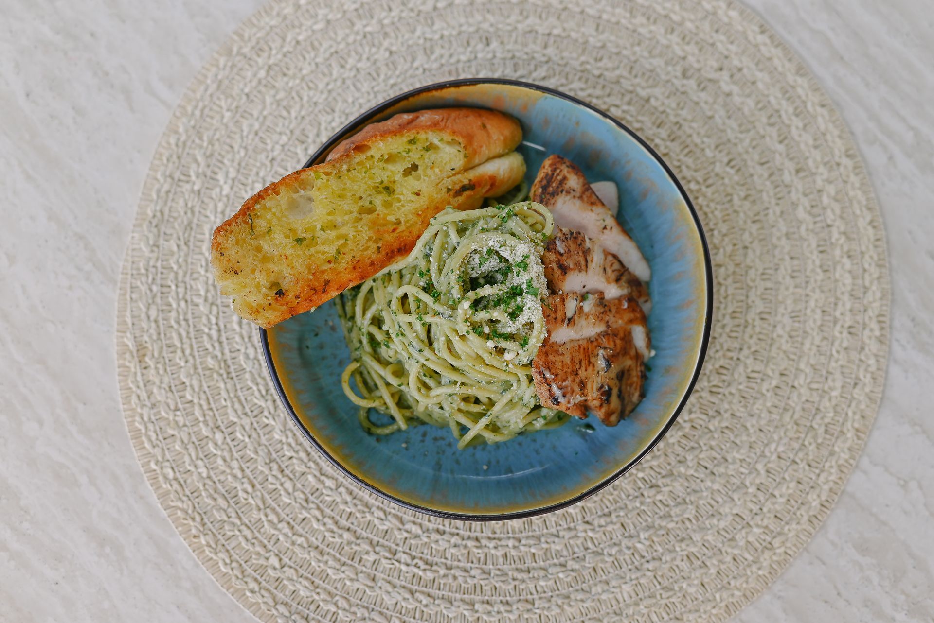 A plate of spaghetti with garlic bread on a table.