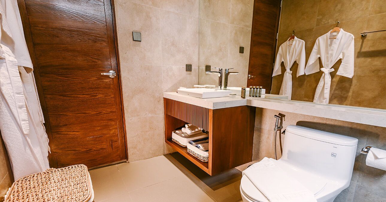 A bathroom with a toilet , sink , and mirror.