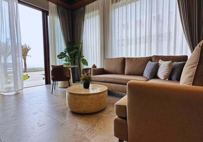 A living room with a couch , chair , table and curtains.
