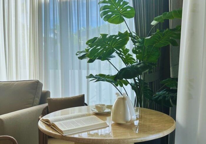 A round table with a book and a plant on it in a living room.