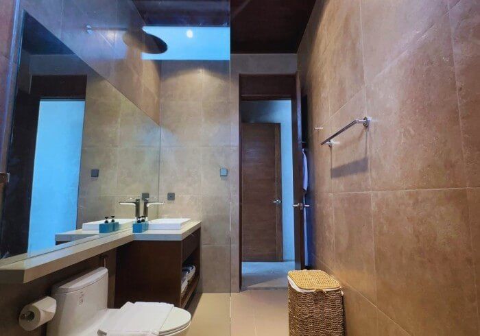 A bathroom with a toilet , sink and mirror.