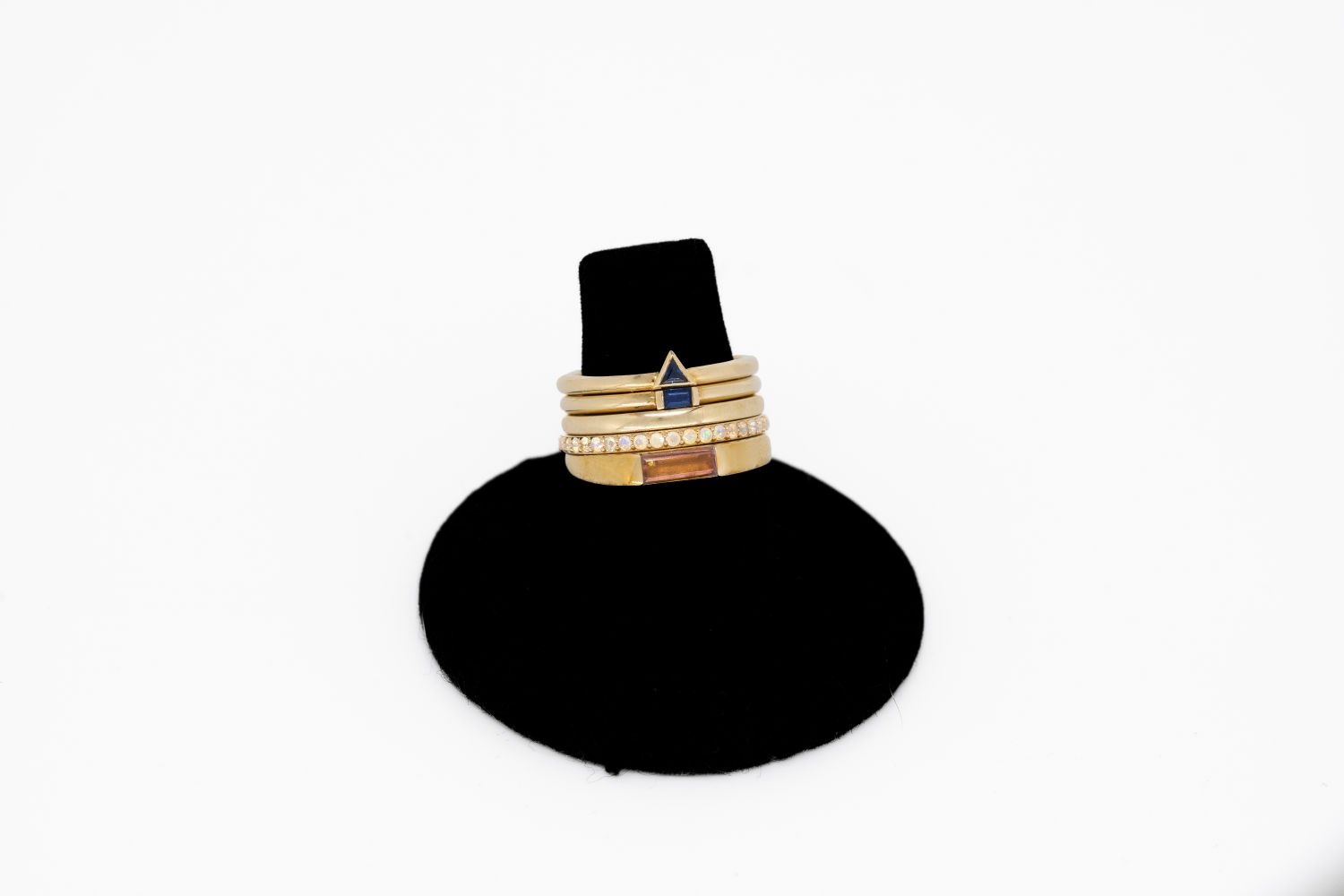 Three rings are stacked on top of each other on a black ring holder.
