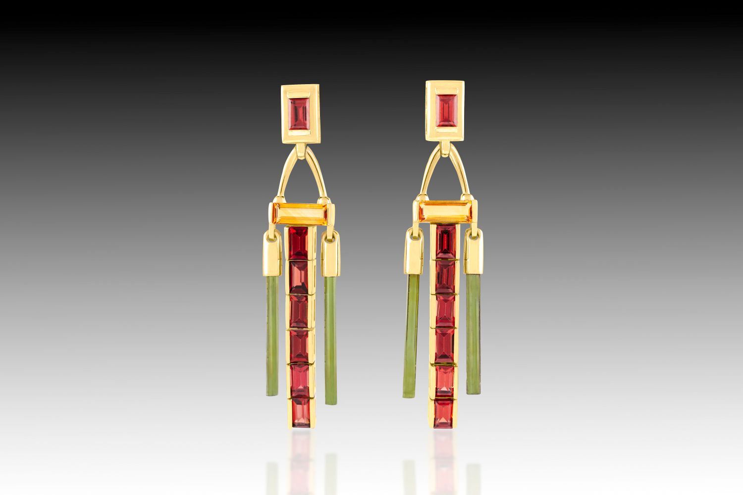 A pair of gold earrings with red and green stones