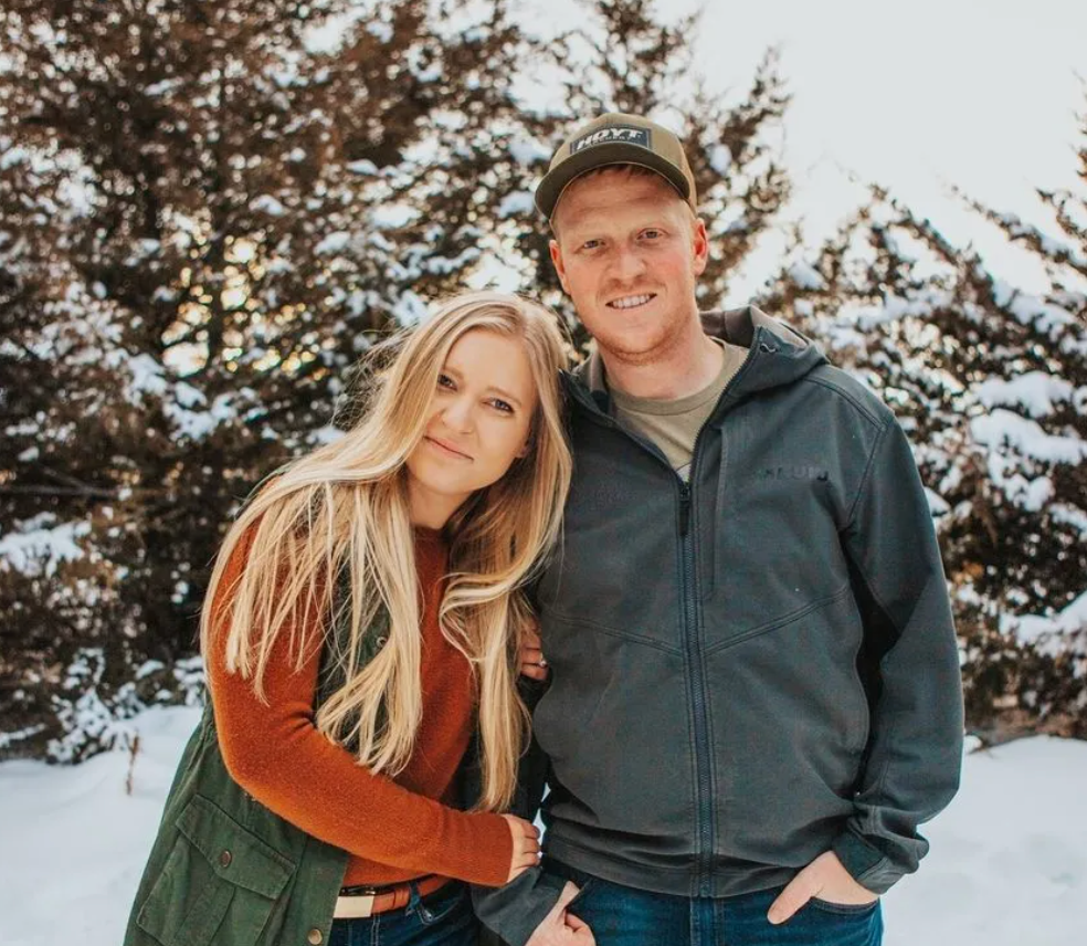 A man and a woman are posing for a picture in the snow.