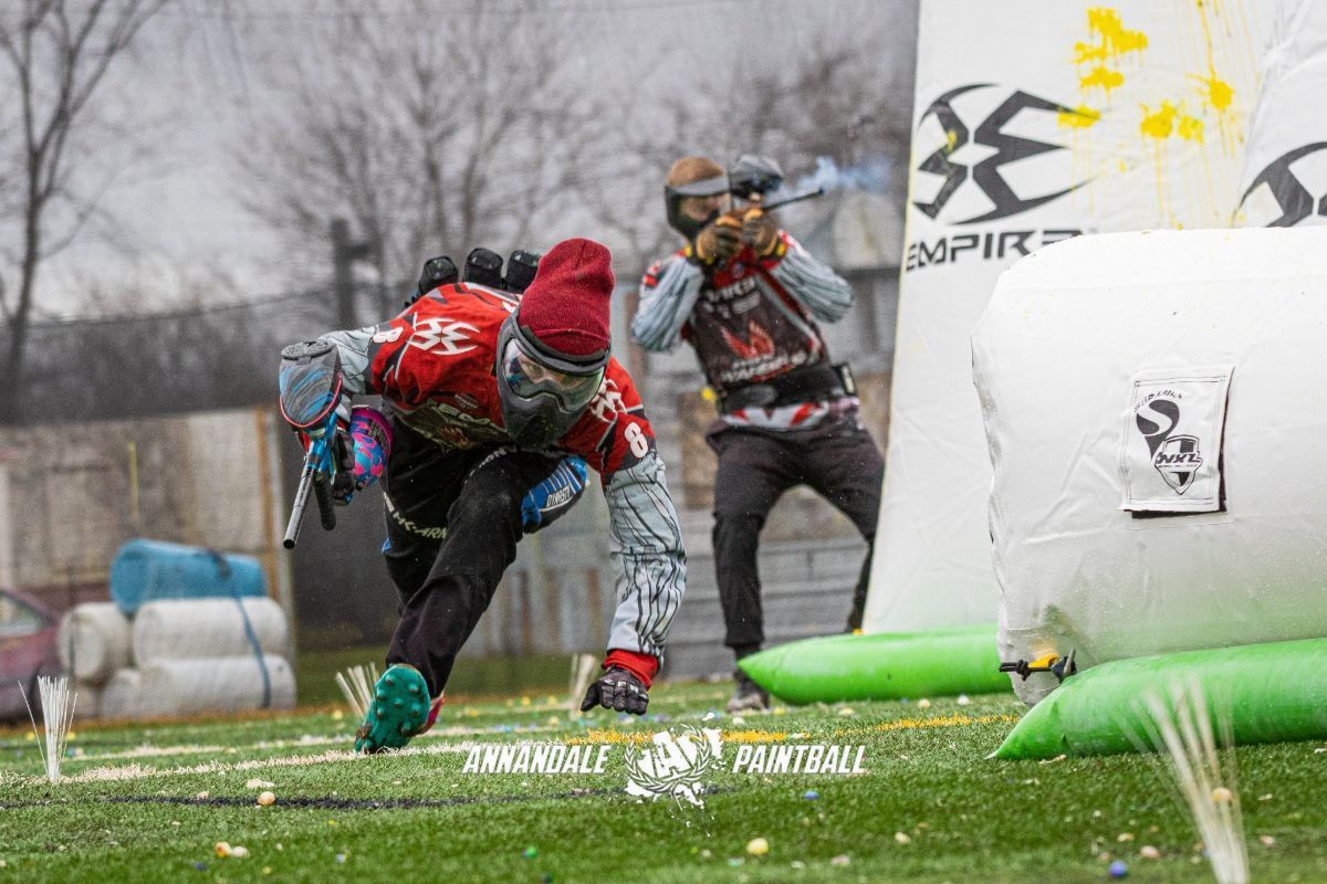 A group of people are playing paintball on a field.