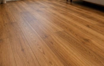 Empty room with warm-toned wooden floorboards and soft natural light
