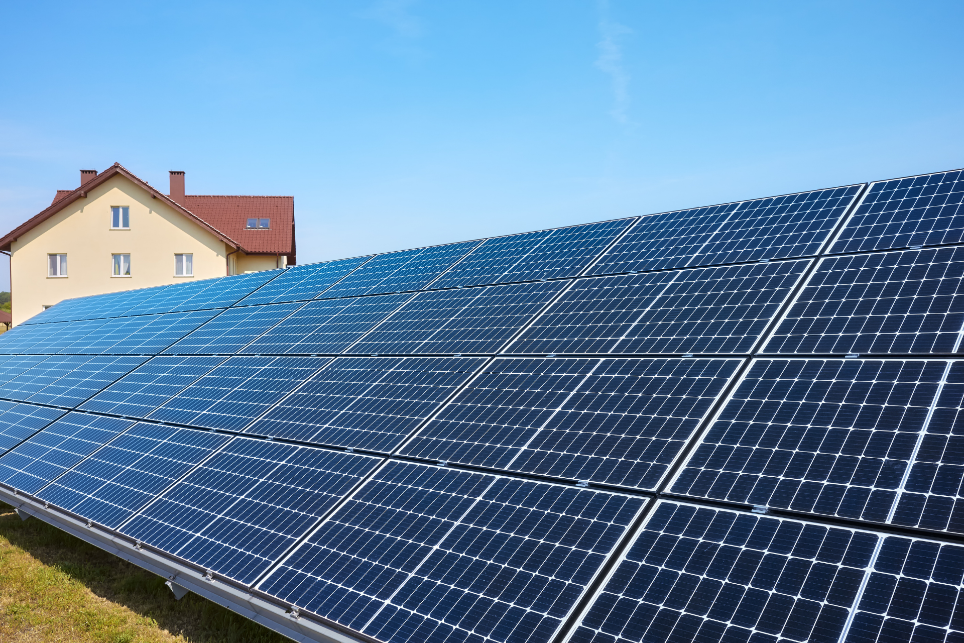 Worker cleaning rooftop solar panels under a sunny blue sky