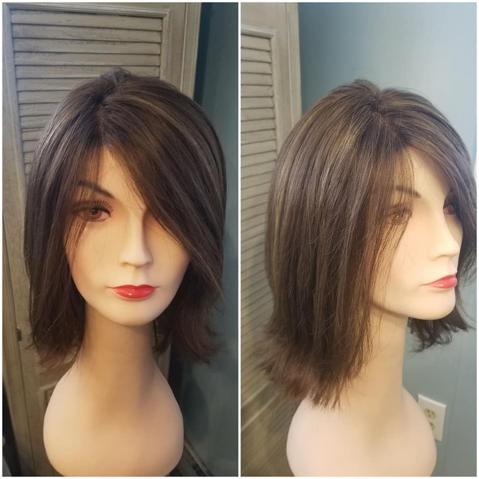 Side-by-side mannequin head with layered brown bob haircut, shown front and profile views on a gray background