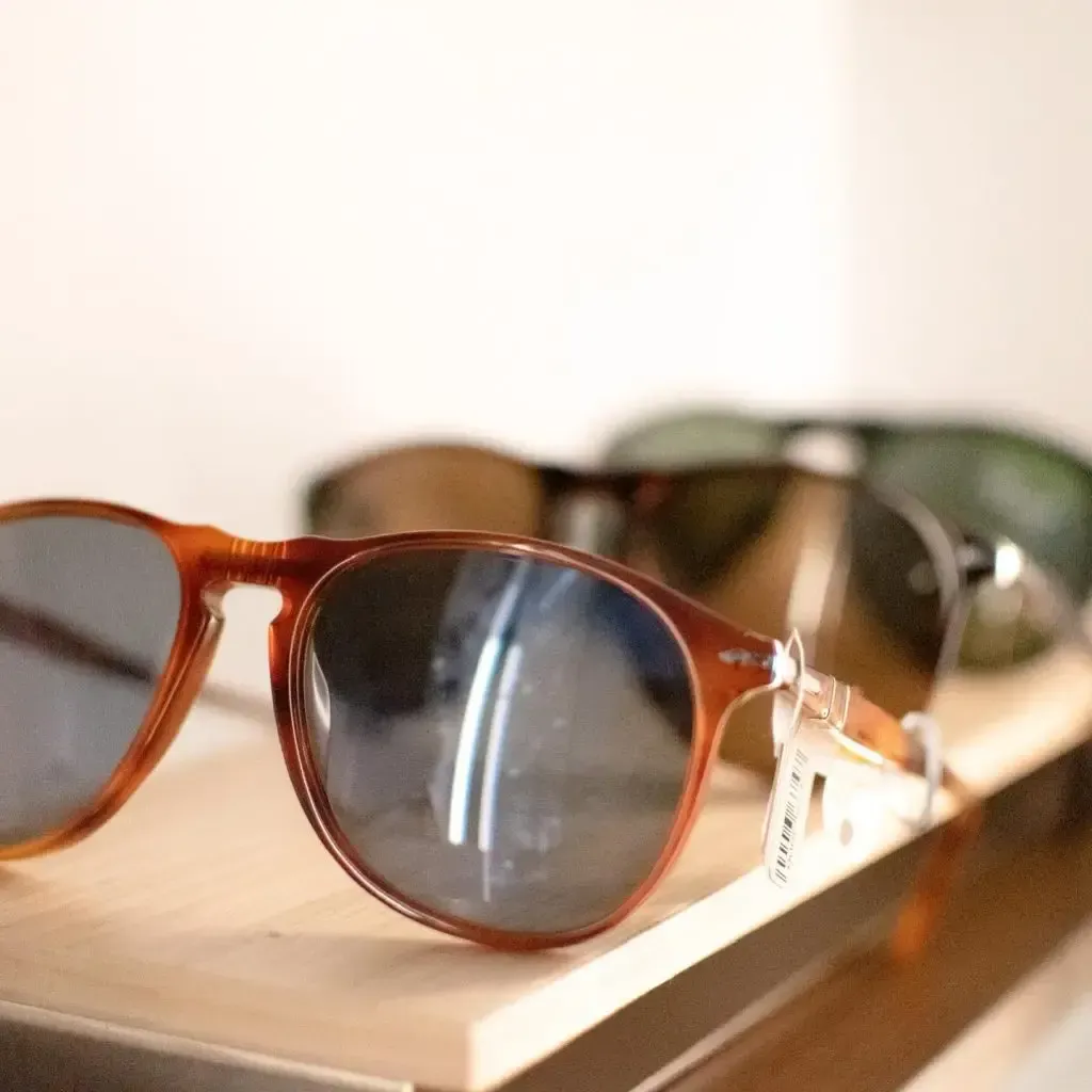 A pair of sunglasses sitting on top of a wooden shelf