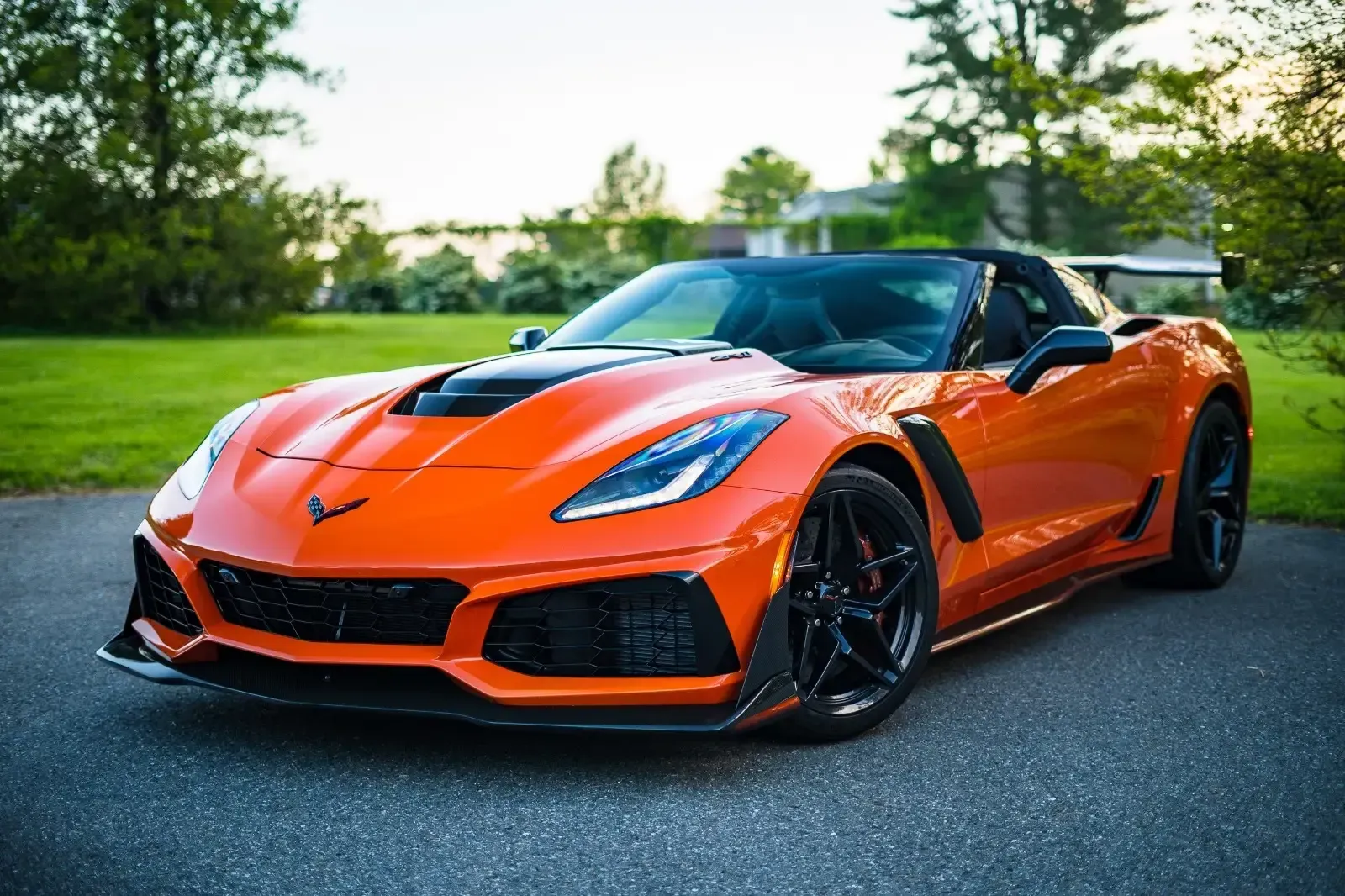 An orange corvette zr1 is parked in a driveway.