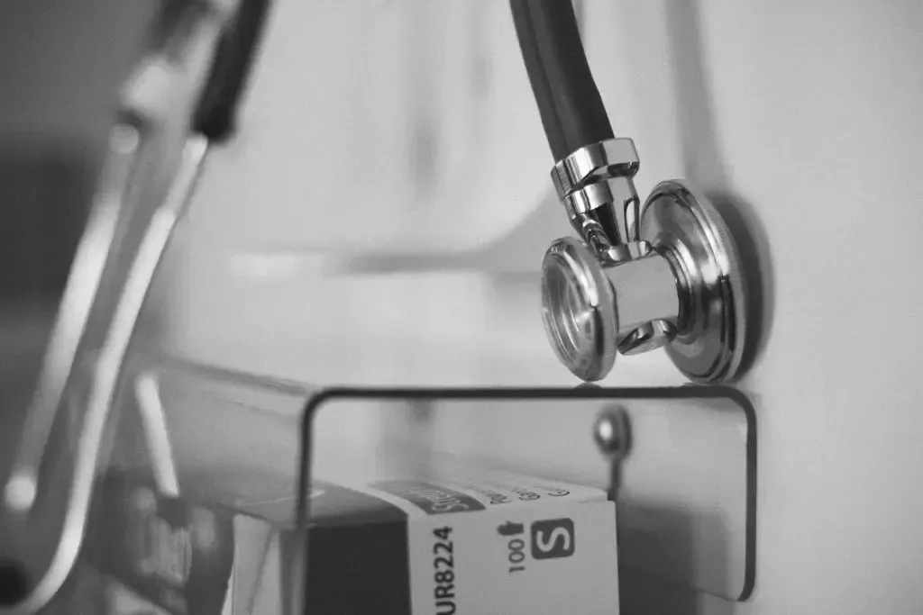 A black and white photo of a stethoscope hanging on a wall.