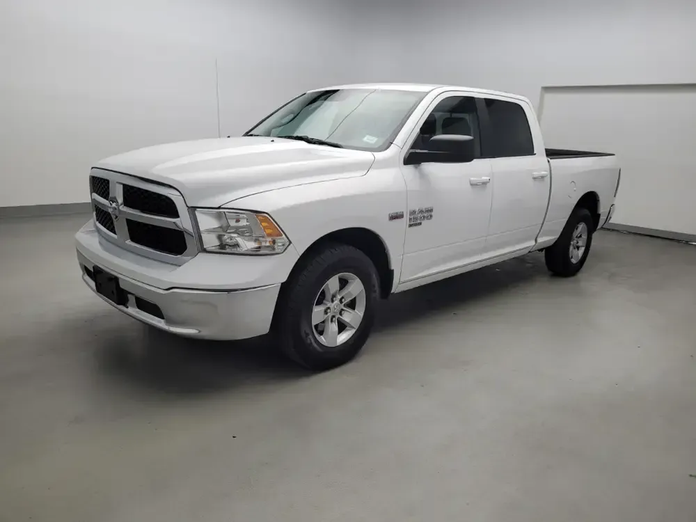 A white dodge ram truck is parked in a garage.