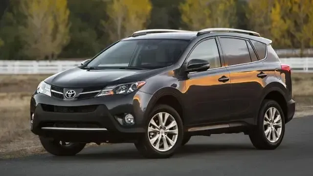 A black toyota rav4 is parked on the side of the road.