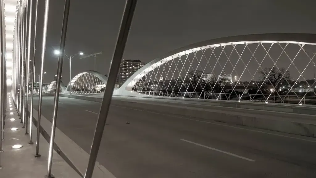A black and white photo of a bridge at night.