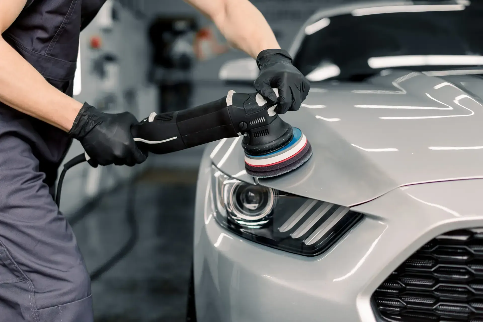 A man is polishing a car with a machine.