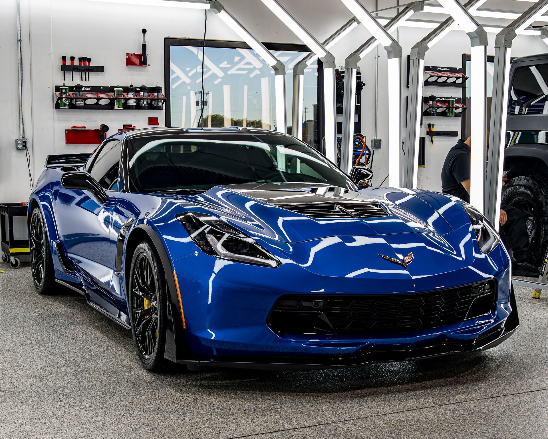 A blue sports car is parked in a garage.