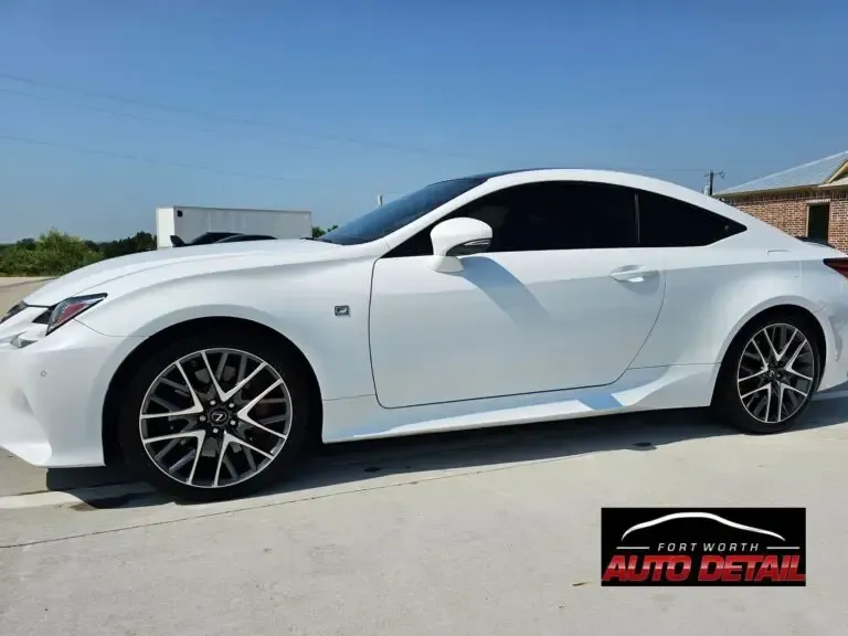 A white sports car is parked on the side of the road