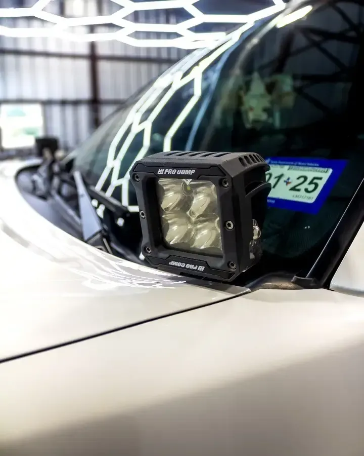 A close up of a car with a light on the hood.