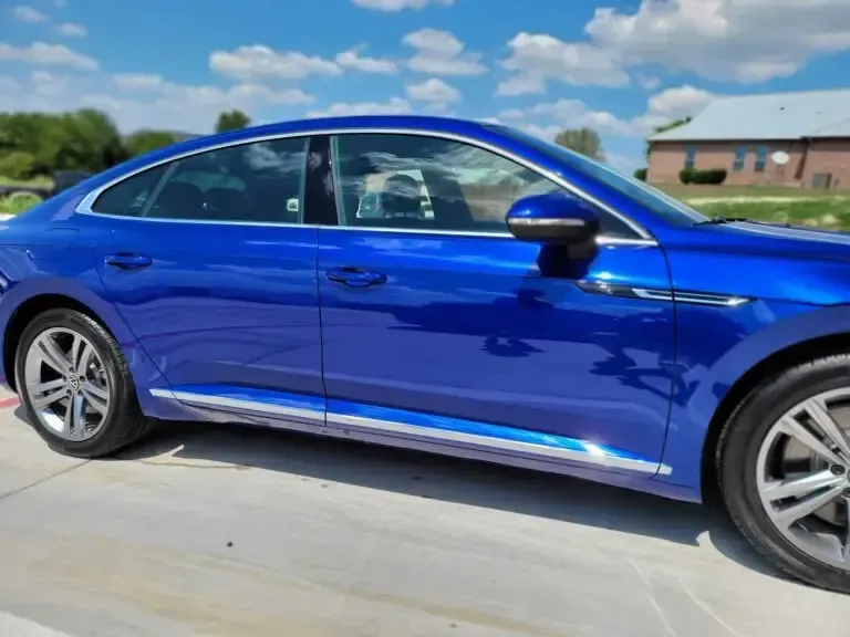 A blue car is parked in a parking lot