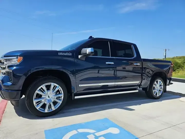 A black truck is parked in a handicapped parking spot.