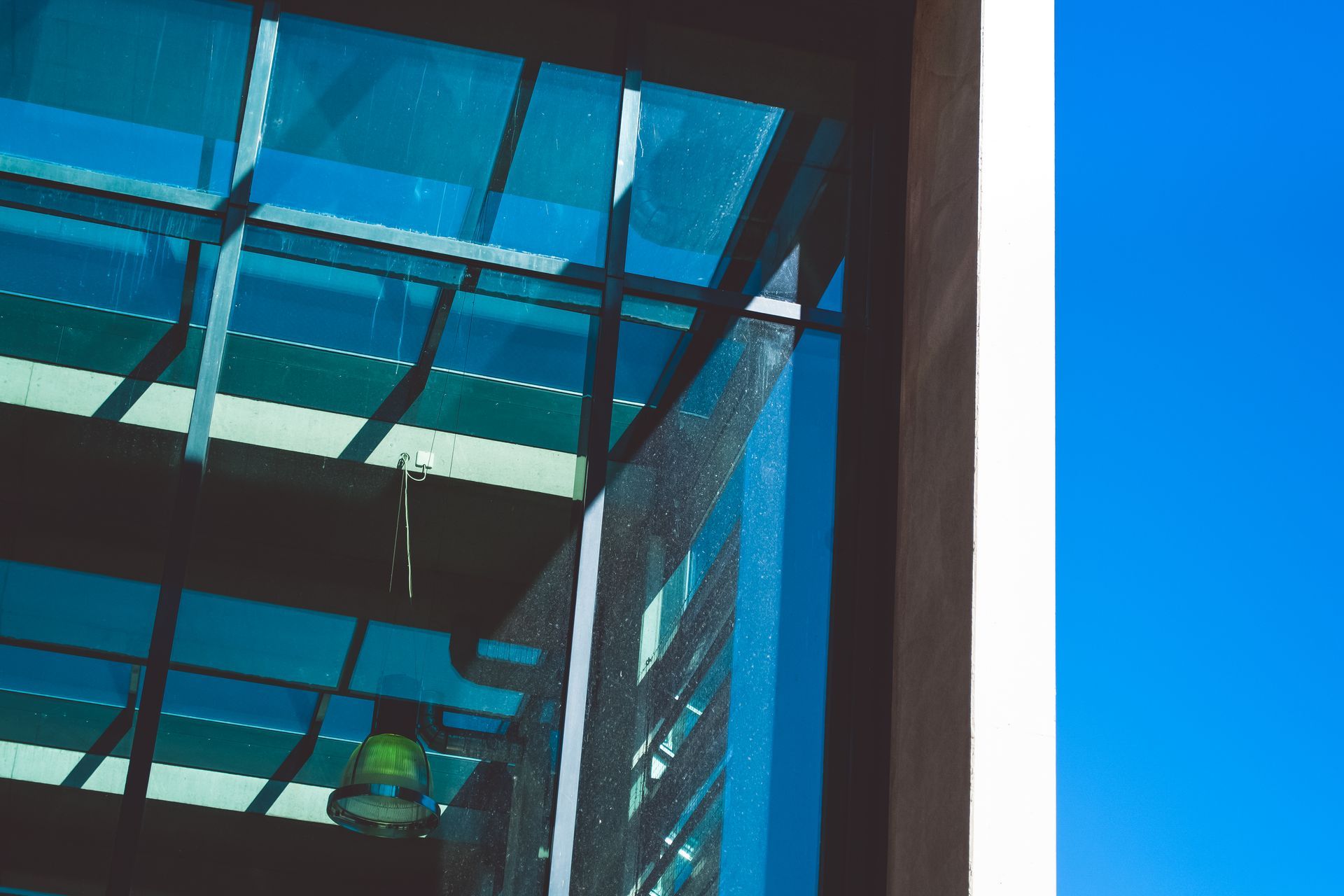 A building with a glass roof and a blue sky in the background
