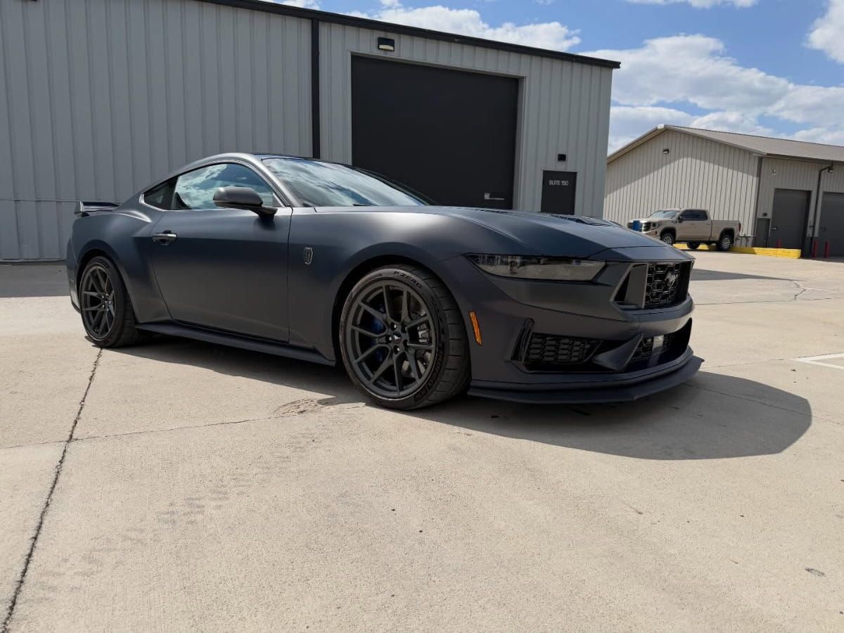Dark gray Ford Mustang Dark Horse parked outside the detailing facility.
