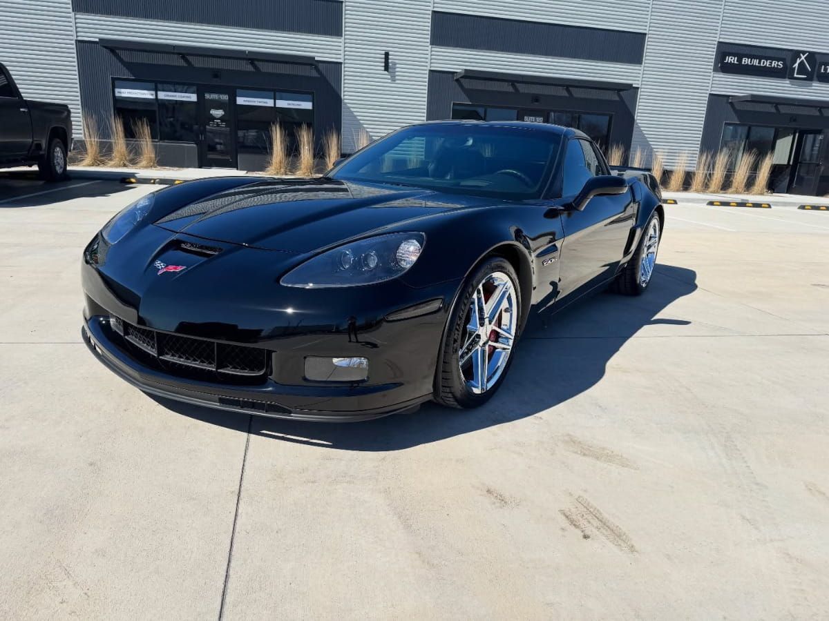 Black Chevrolet Corvette Z06 with a glossy finish parked outside.