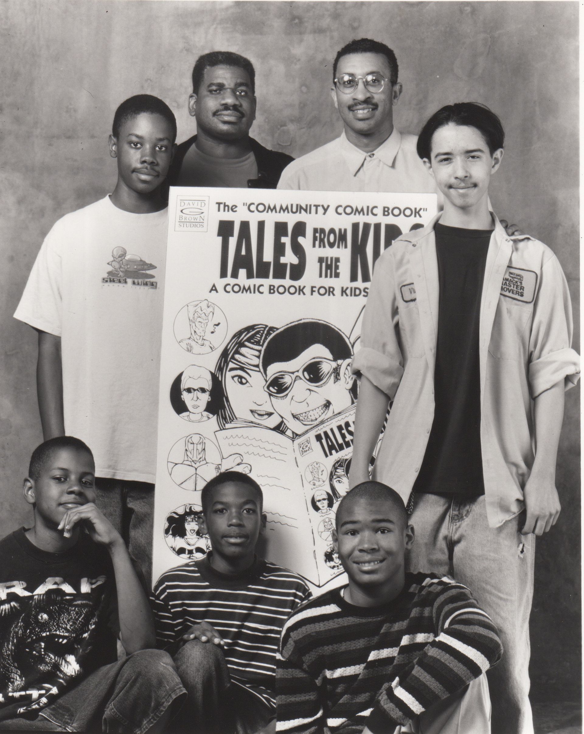 Group of men, young and older, pose with a