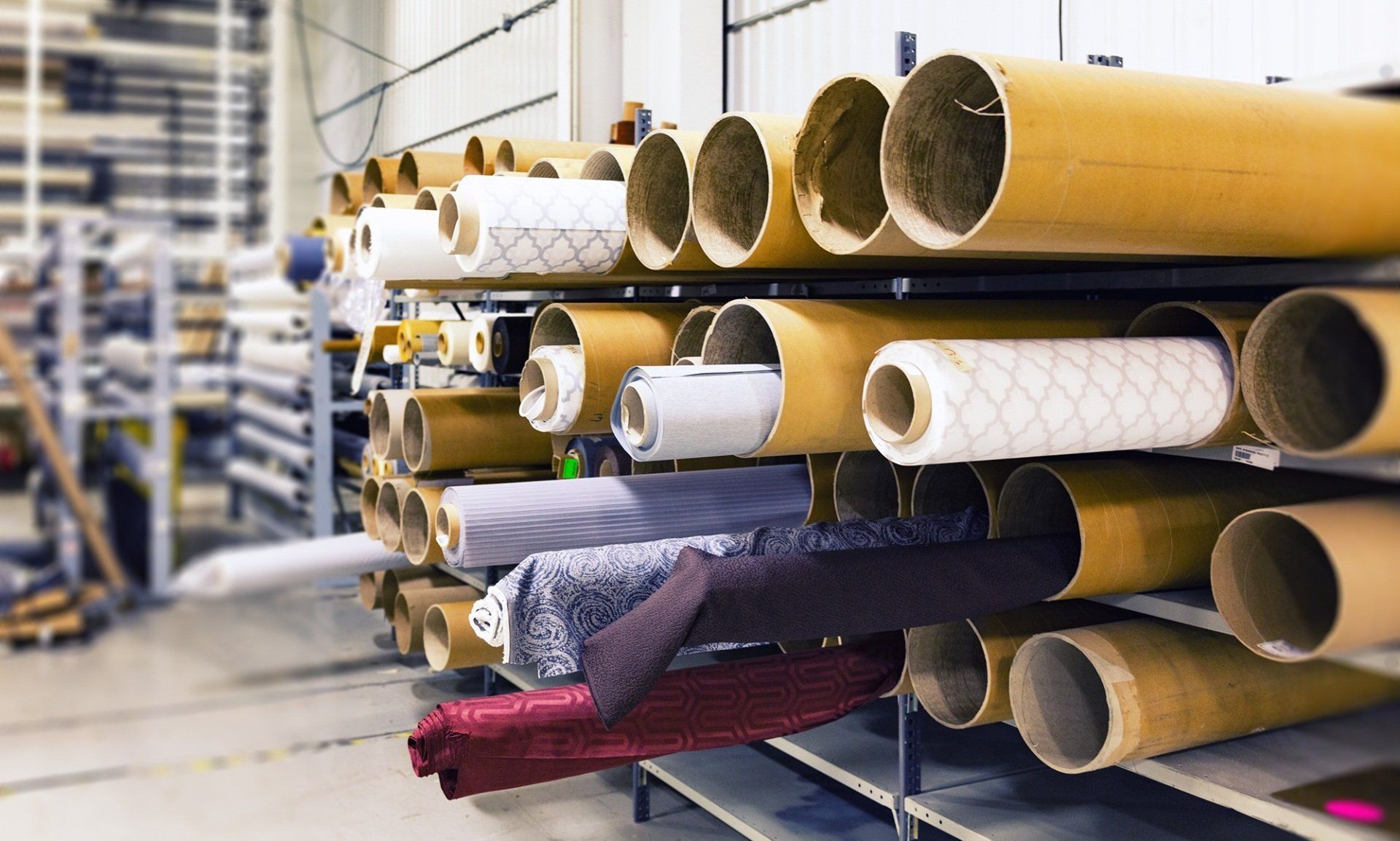 Fabric rolls stored on shelves in a warehouse.