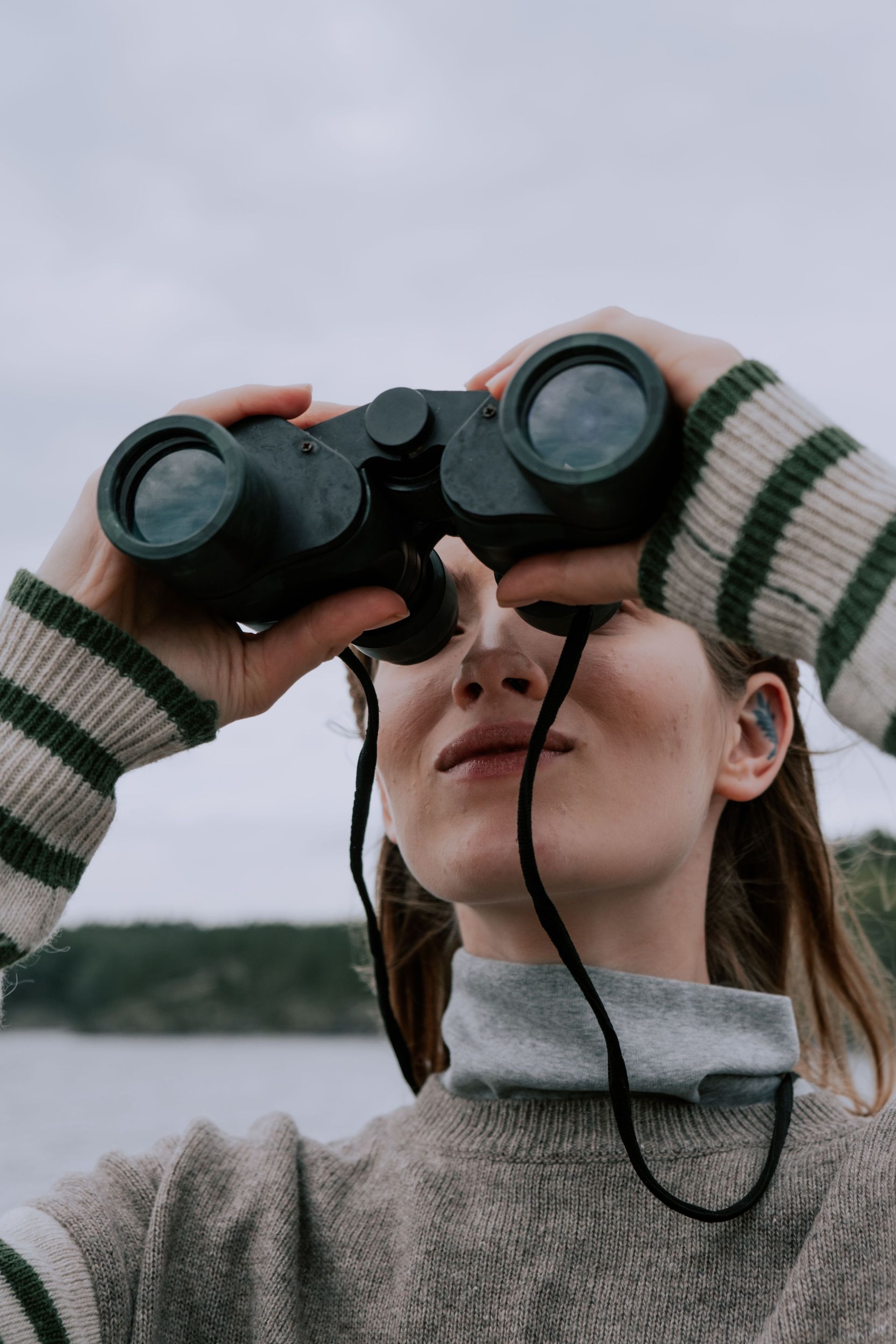 A woman searching using binoculars