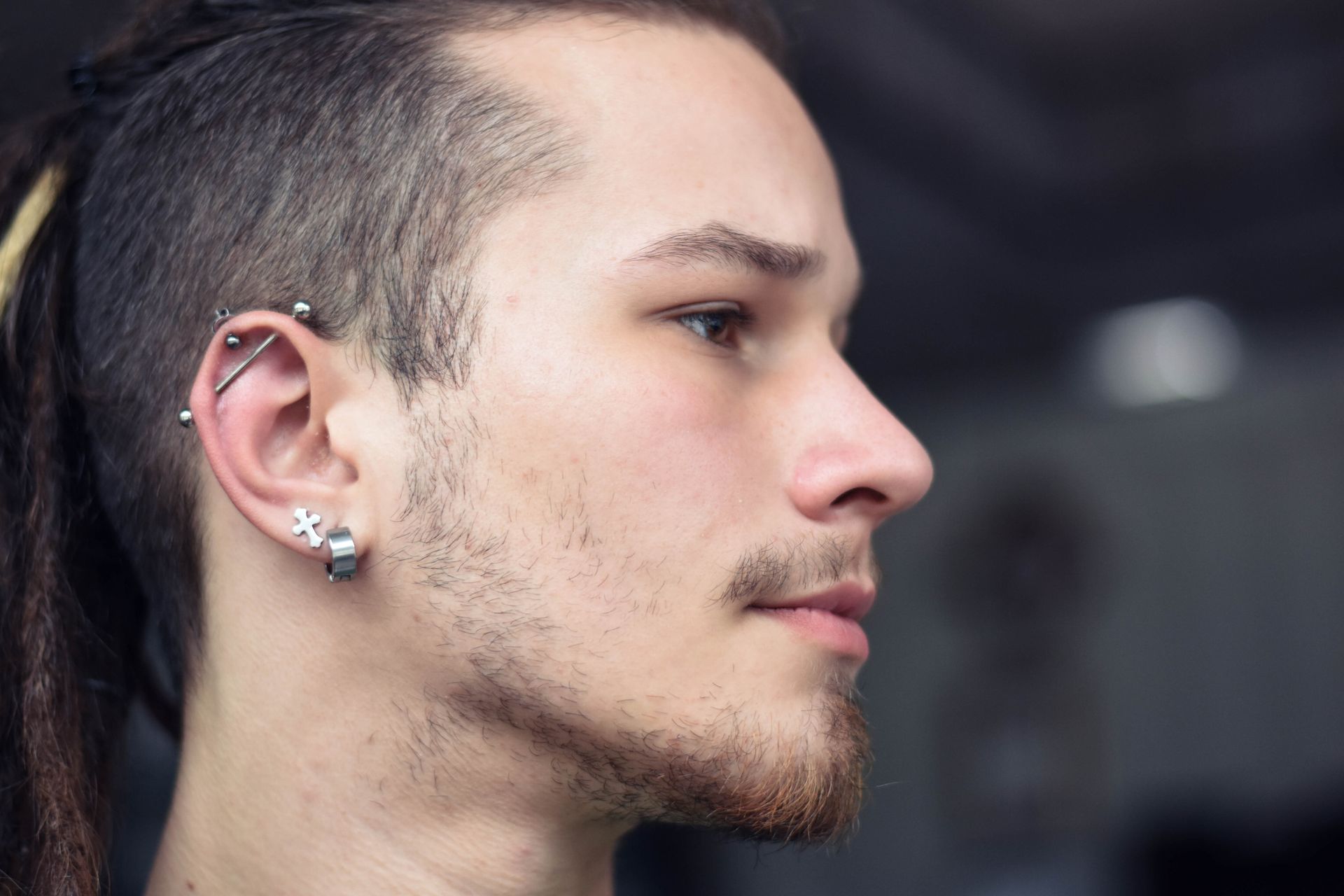 Portrait of a young male with a cartilage piercing looking to the side Portrait of a young male with a cartilage piercing looking to the side