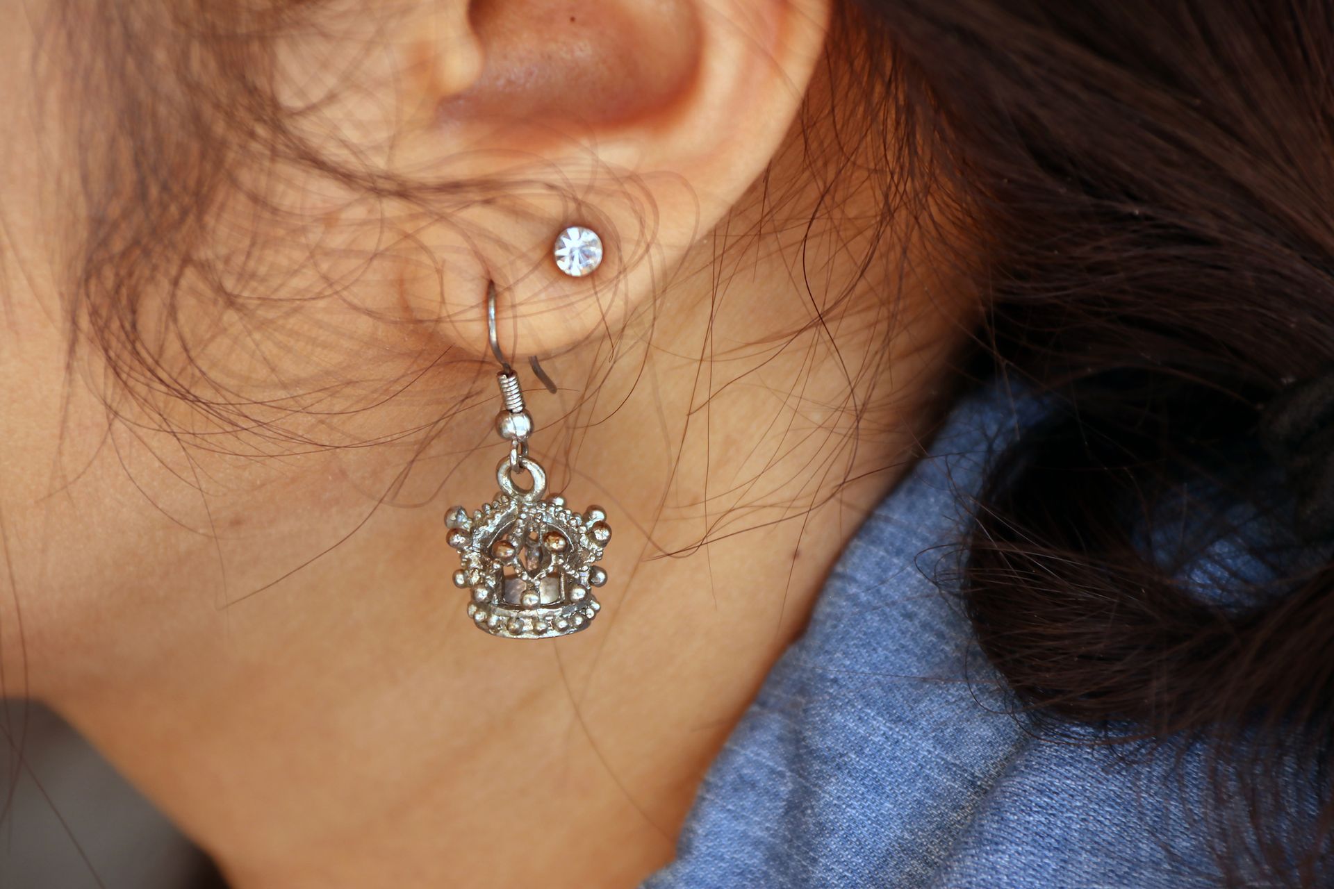 Crown-shaped metal earring with a diamond accent on the ear, showcasing stylish ear curation from Studio 28 in Manhattan, NY Crown-shaped metal earring with a diamond accent on the ear, showcasing stylish ear curation from Studio 28 in Manhattan, NY