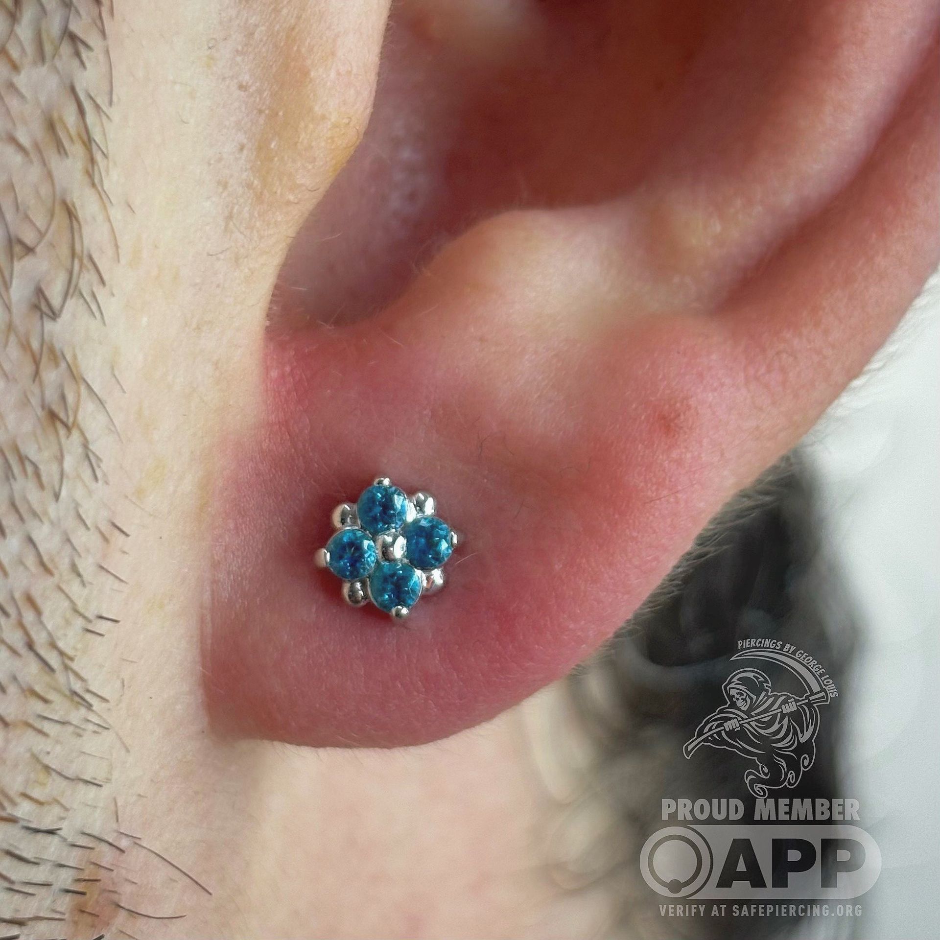 Close-up of ear with a cluster of blue gemstone earrings.