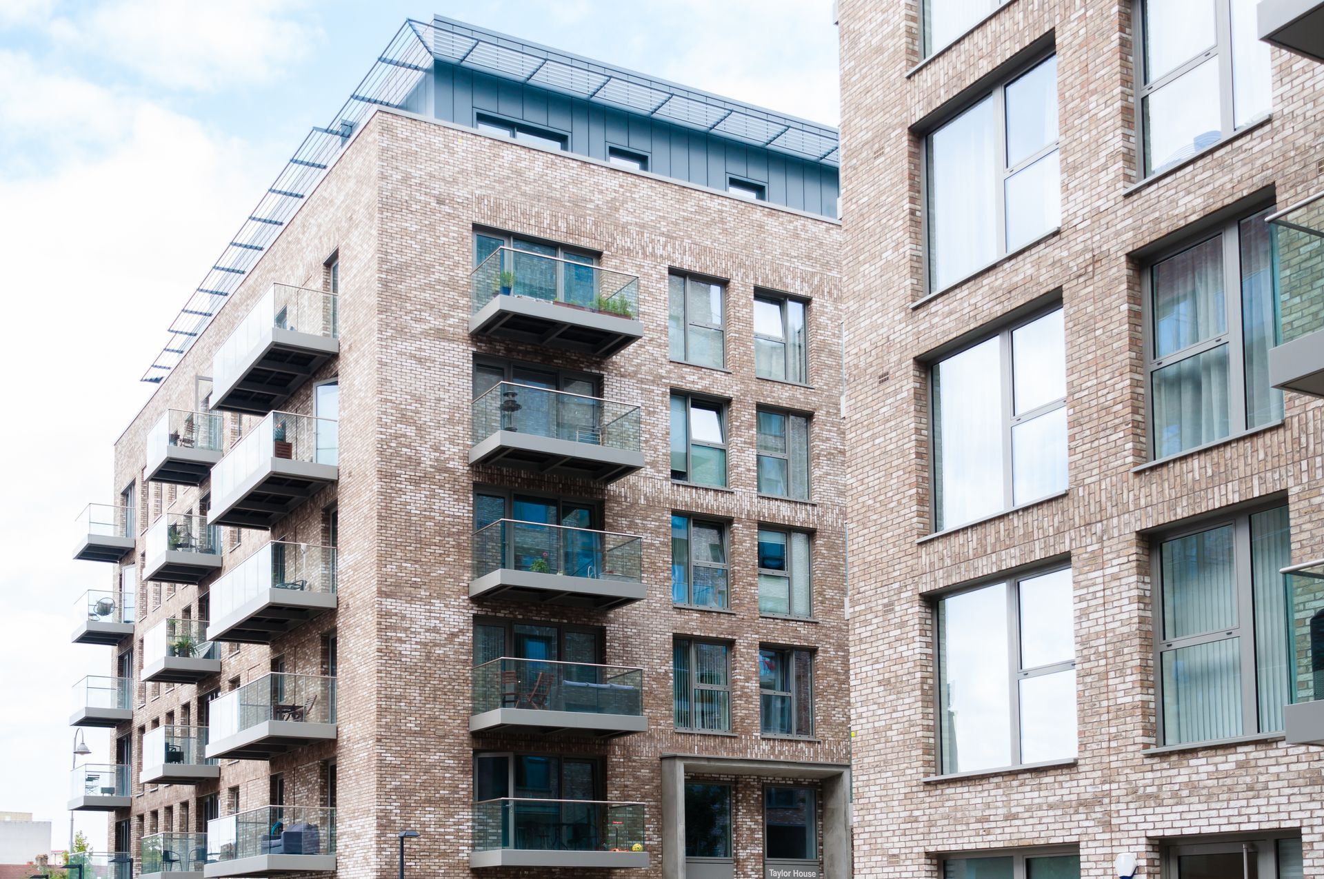A large brick apartment building with lots of windows and balconies.