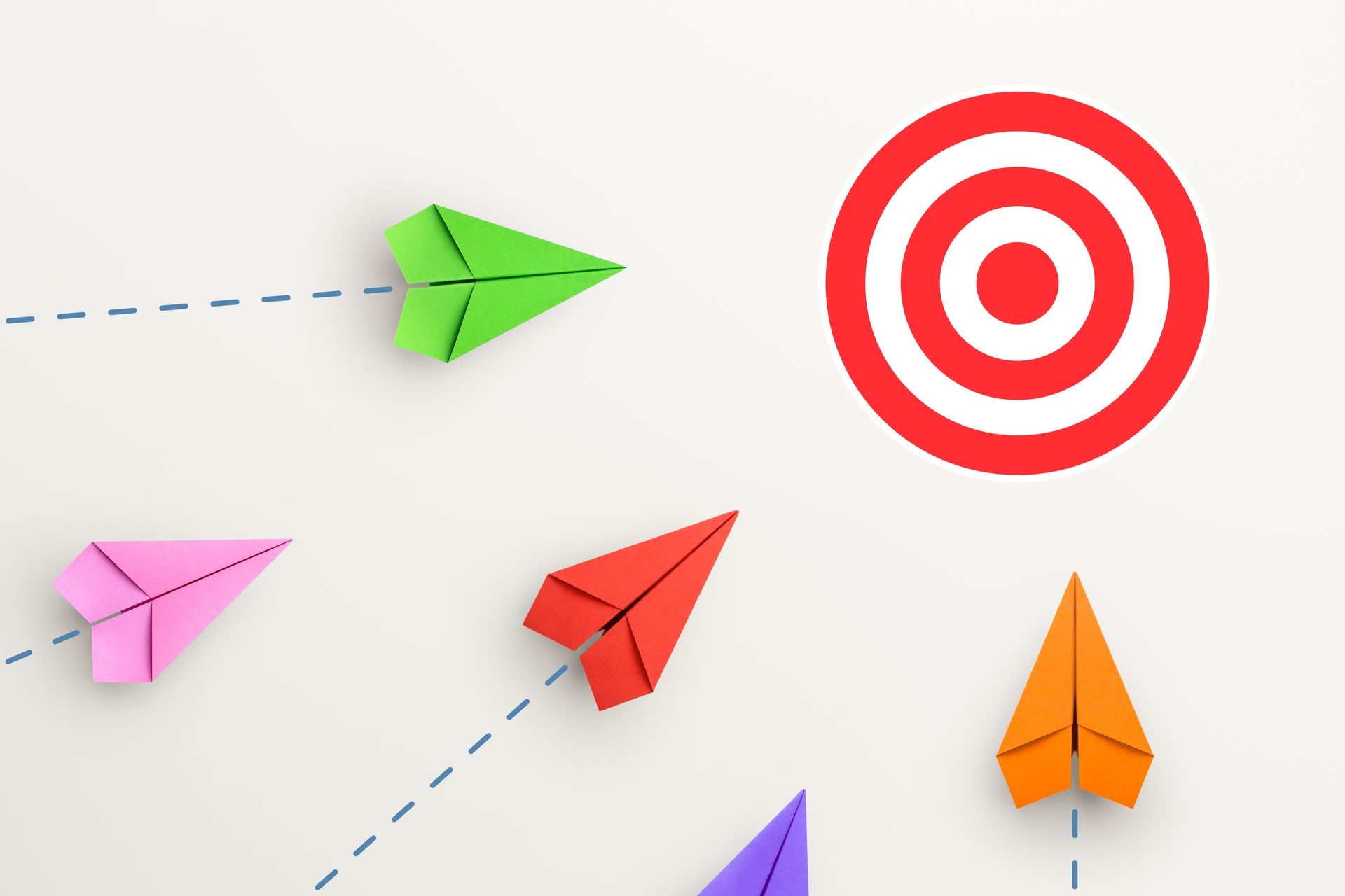 A group of paper airplanes are flying towards a target.