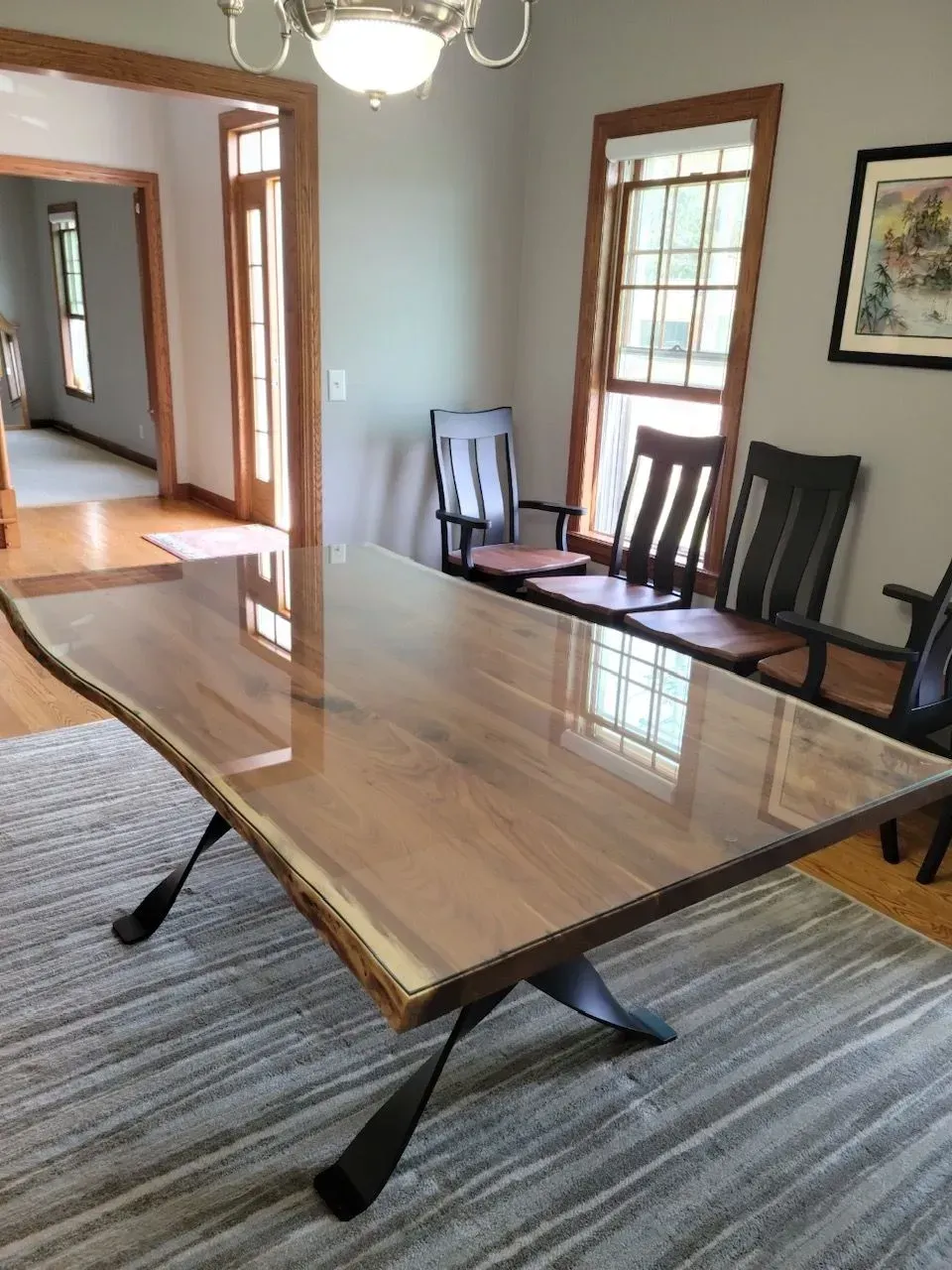 A dining room with a large wooden table and chairs