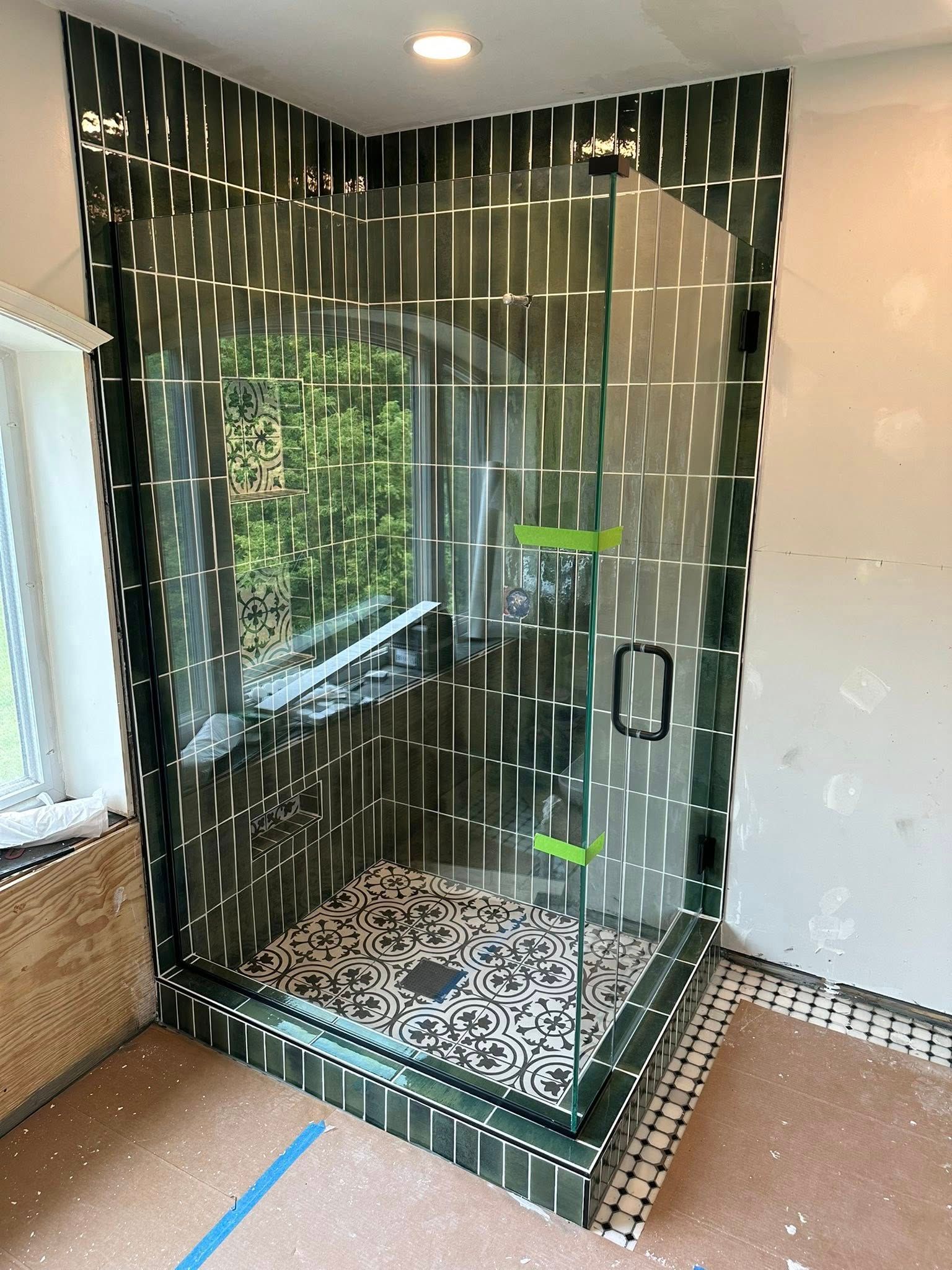 Newly constructed corner shower with dark green tile, glass door in Janesville, WI