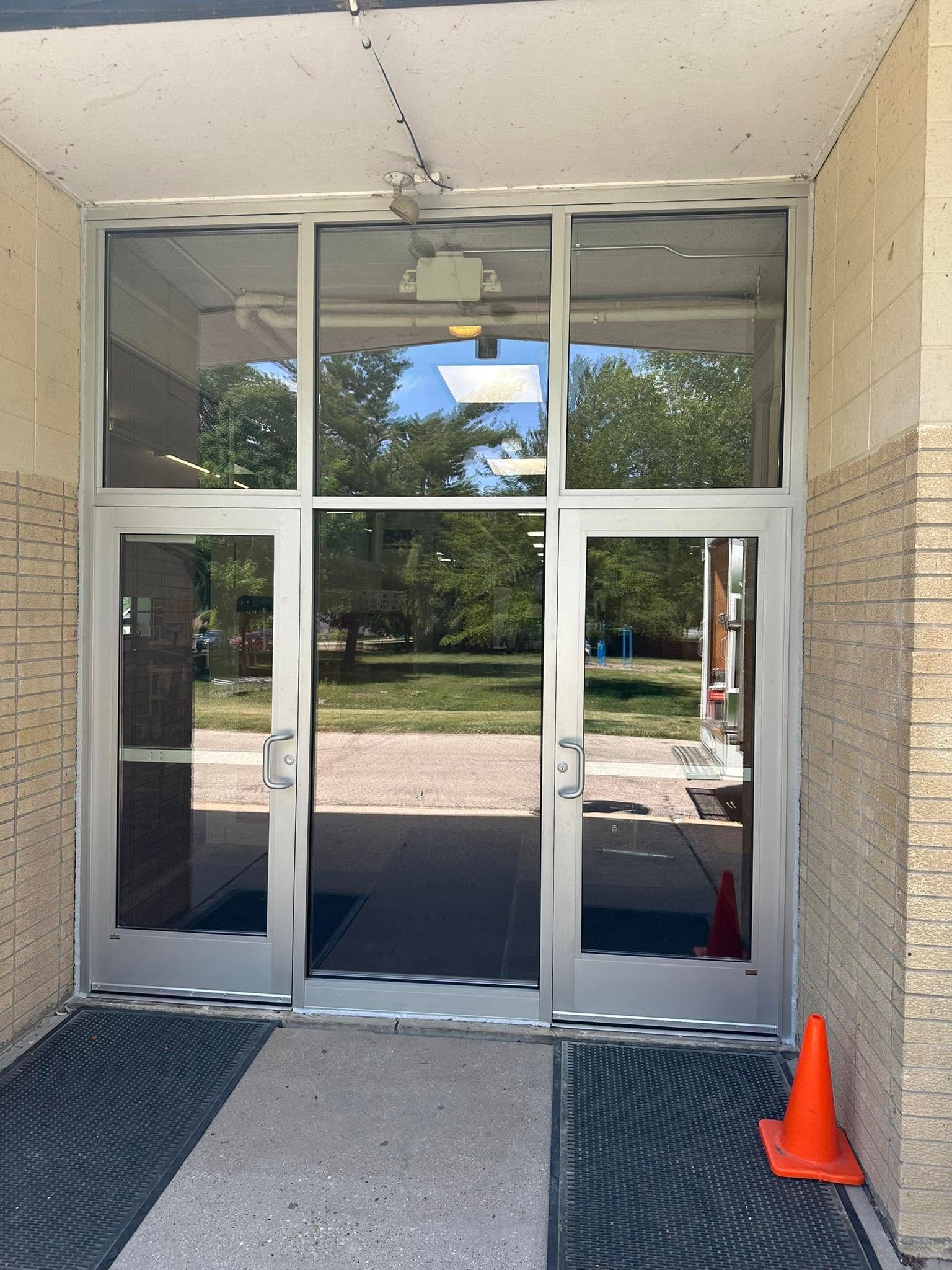 Interior commercial glass door with full-height sidelight installed in a Janesville, WI building