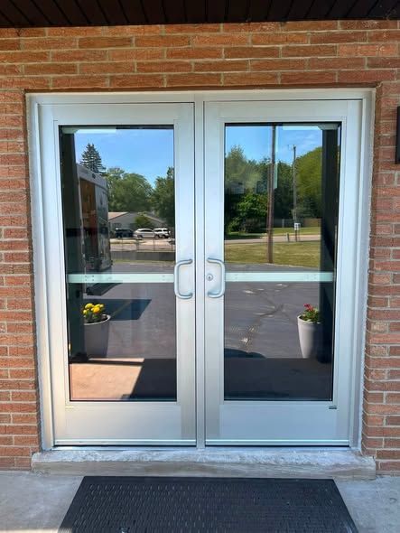 New aluminum double entry doors installed in a brick commercial building in Janesville, WI