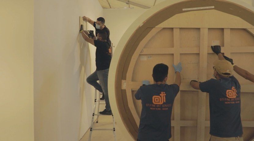 The OTI team using a lift to install a large sculpture