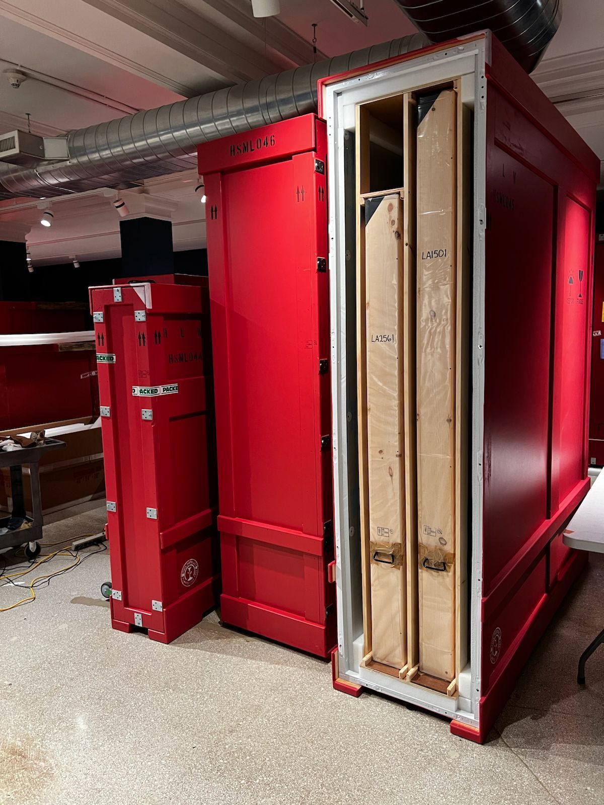 A large red box with a wooden door is sitting in a room.