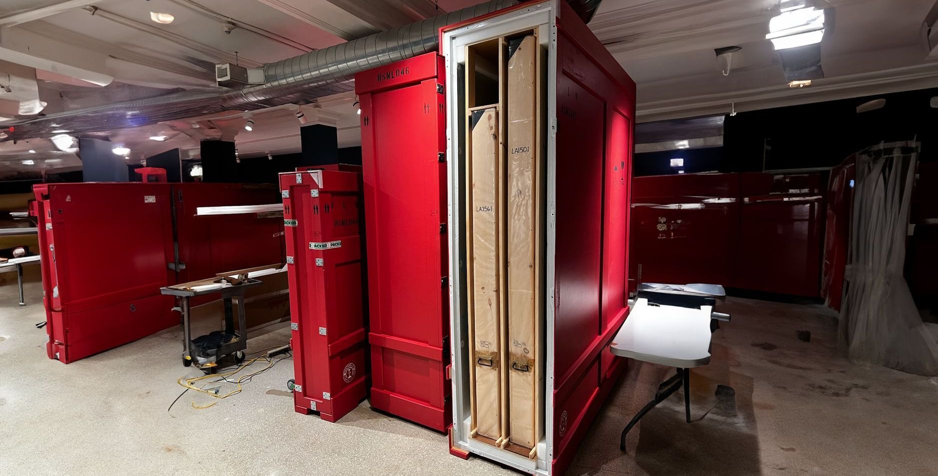A room with a lot of red boxes and a table.